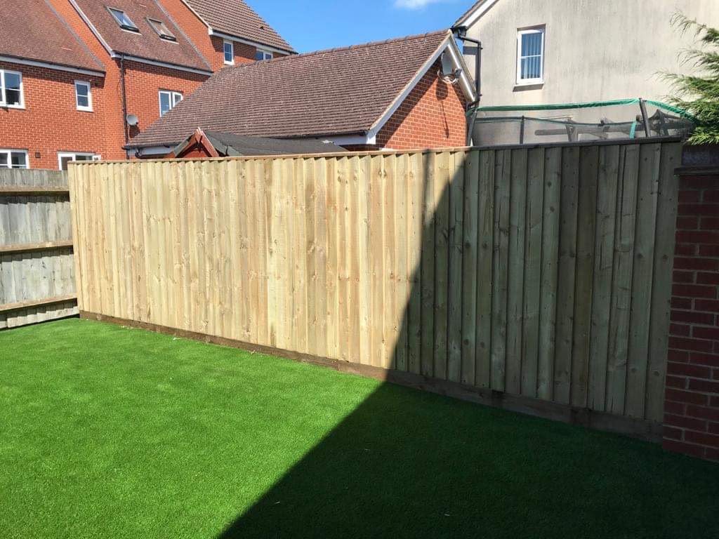 Newly installed closeboard timber fencing along a garden boundary